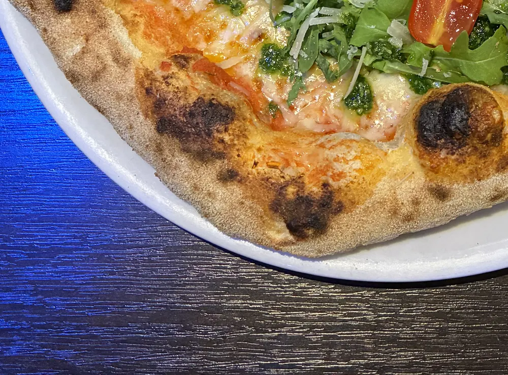 Cornicione einer neapolitanischen Pizza mit den typischen dunklen Leopardenflecken