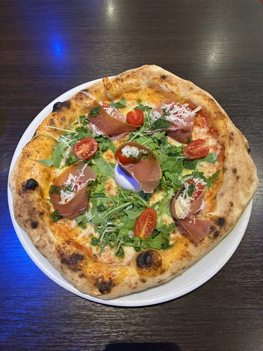 La Burrata e Parma — neapolitanische Steinofenpizza mit Parmaschinken, Burrata, Rucola, Cherrytomaten und Pesto