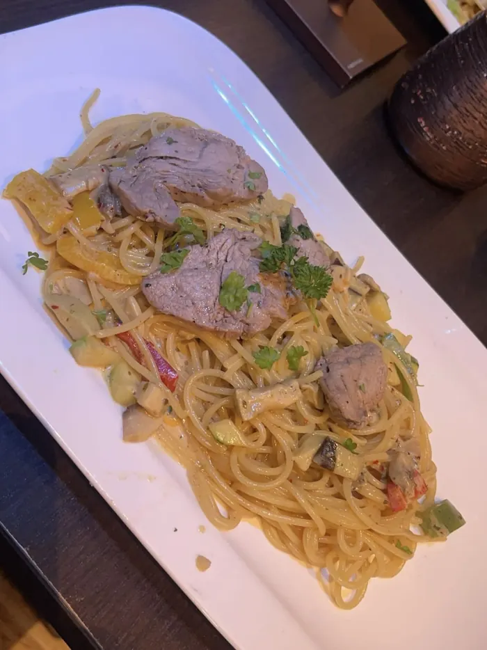 Spaghetti mit Fleischscheiben, Zucchini, Paprika und Champignons in heller Sauce